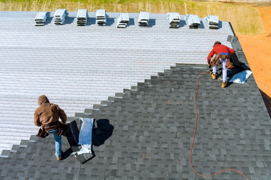 how to finance a roof replacement - two men working on installing new roofing